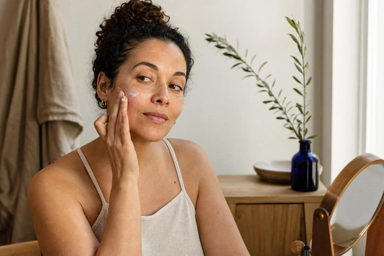 A woman applying skincare during a quiet morning routine